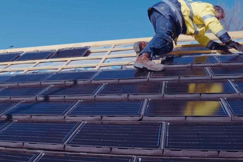 Couvreur sur un toit en cours d'installation de tuiles solaires